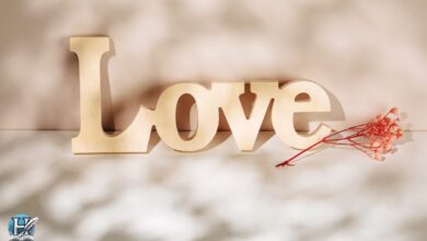 حب مكتوب بكلمة Love بجانب وردة حمراء – تعبير بصري عن مشاعر الحب والرومانسية.