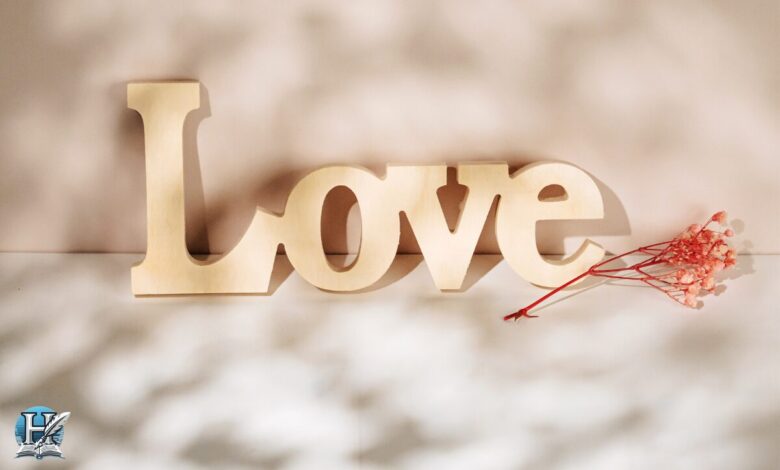 حب مكتوب بكلمة Love بجانب وردة حمراء – تعبير بصري عن مشاعر الحب والرومانسية.
