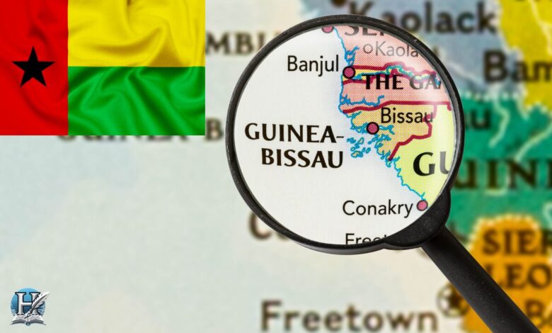 خريطة تُظهر موقع دولة غينيا بيساو في غرب إفريقيا تحت عدسة مكبرة، مع ظهور علم الدولة في الزاوية.