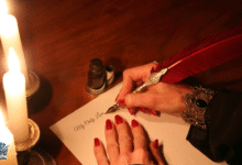 امرأة تكتب رسالة رومانسية باستخدام ريشة حمراء وحبر على ضوء الشموع.