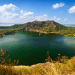 صورة لبركان تال في الفلبين، يظهر البركان داخل بحيرة تال وفوهته النشطة محاطة بالمناظر الطبيعية الخلابة.