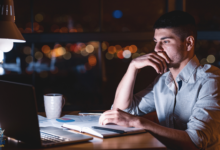 متعلم برمجة يجلس أمام شاشة حاسوب مليئة بالكود ويشعر بالشك والتردد